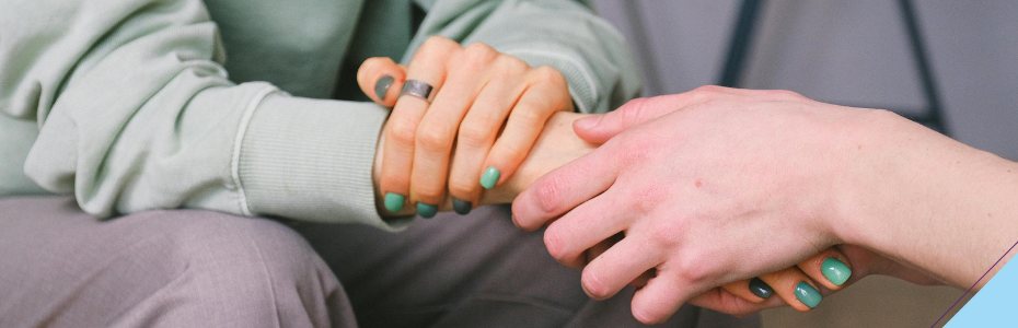 Hände, die sich gegenseitig halten und sich so in der Trauer Trost spenden.